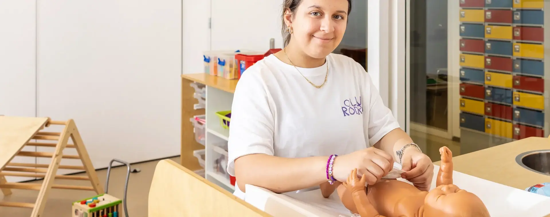 Meisje verschoont luier van dummybaby