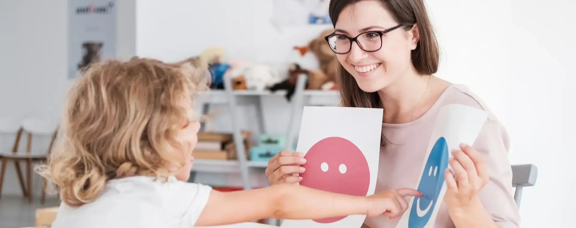 Assistent met kind die lachend gezicht aanwijst op A4