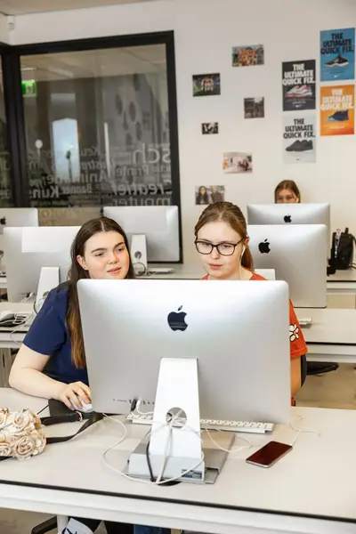 Twee studenten zitten samen achter een Imac te werken