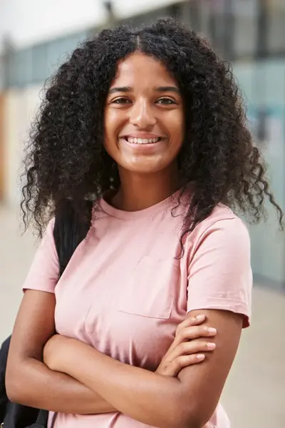 meisje in een roze t-shirt staat in de hal van een school