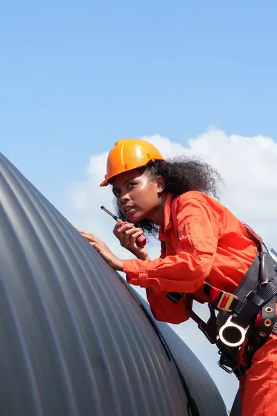 Student onderhoudstechniek op ladder met walkietalkie