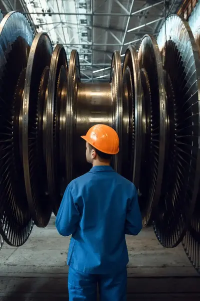 Student in werkkleding inspecteert machine