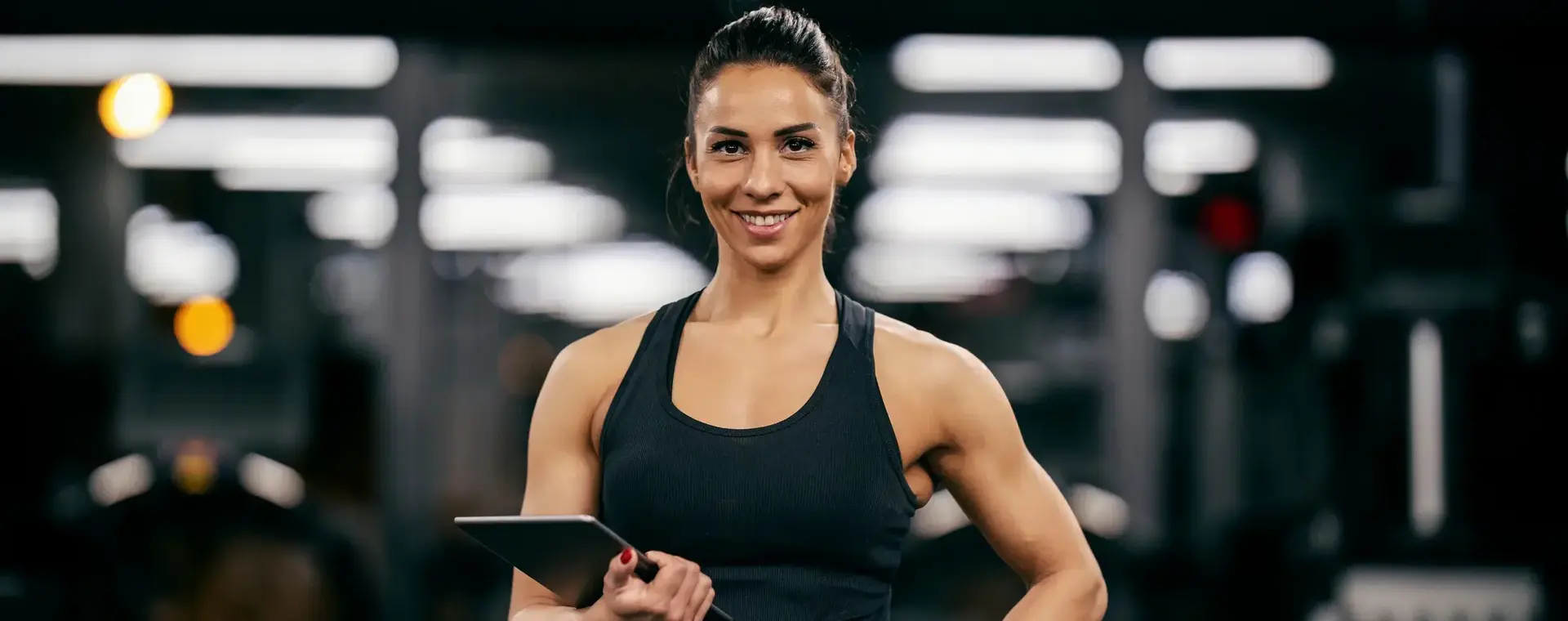 Gespierde dame met tablet in sportschool
