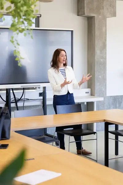 Docent geeft les aan studenten in een klaslokaal met laptops
