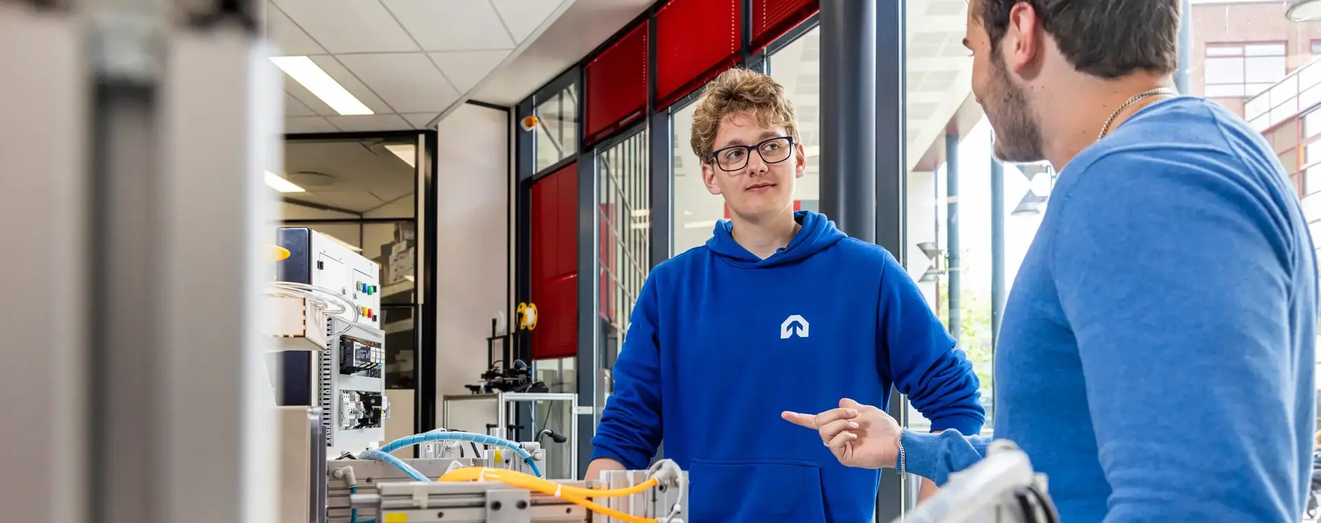 Student en docent staan naast technische installatie